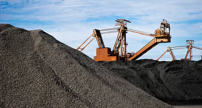 Manganese ore in stockpile at harbor loading site in Port Hedland, Pilbara, Western Australia.cReclaimer and stacker