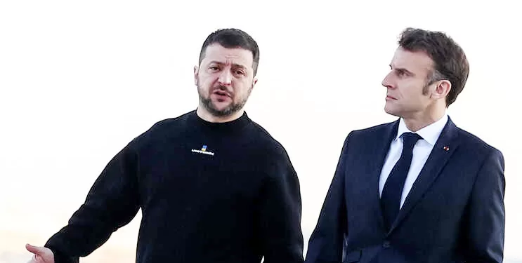 France's President Emmanuel Macron (R) and Ukrainian President Volodymyr Zelensky walk on the tarmac of Velizy-Villacoublay airbase as they prepare to board a flight together, en route to Brussels for a summit at EU parliament, on February 9, 2023. - Ukraine's President is set to attend an EU summit in Brussels on February 9, 2023, as the guest of honour where he will press allies to deliver fighter jets "as soon as possible" in the war against Russia. (Photo by MOHAMMED BADRA / POOL / AFP)