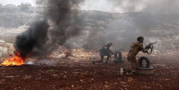 Fighters affiliated with Syria's "Hayat Tahrir al-Sham" (HTS) rebel-group, take part in a military excercise on attacking tactics with live ammunition, on the outskirts of the northwestern province of Idlib, on November 8, 2022. - The last pocket of armed opposition to Syrian President Bashar al-Assad's regime includes large swathes of Idlib province and parts of the neighbouring Aleppo, Hama and Latakia provinces. Hayat Tahrir al-Sham (HTS), headed by ex-members of Syria's former Al-Qaeda franchise, is the dominant group in the area but other rebel groups are also active. (Photo by OMAR HAJ KADOUR / AFP)