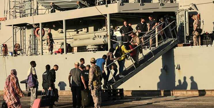 In this picture taken on May 5, 2023, people from various nationalities board the Spanish frigate Reina Sofia during an evacuation from Port Sudan toward Saudi Arabia, as violence continues between two rival Sudanese generals. - The US and Saudi governments confirmed direct talks between the warring Sudanese army and the Rapid Support Forces would start in Jeddah on May 6, 2023, even as fighting showed little signs of abating in the Sudanese capital. (Photo by AFP)