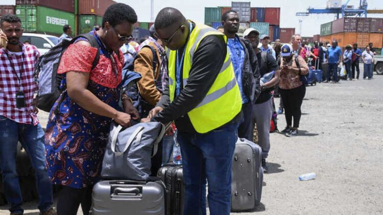People fleeing war-torn Sudan queue to board a boat from Port Sudan on April 28, 2023. - Fighting raged in Sudan despite rival forces agreeing to extend a truce aimed to stem nearly two weeks of warfare that has killed hundreds and caused widespread destruction. (Photo by AFP)
