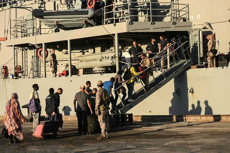 In this picture taken on May 5, 2023, people from various nationalities board the Spanish frigate Reina Sofia during an evacuation from Port Sudan toward Saudi Arabia, as violence continues between two rival Sudanese generals. - The US and Saudi governments confirmed direct talks between the warring Sudanese army and the Rapid Support Forces would start in Jeddah on May 6, 2023, even as fighting showed little signs of abating in the Sudanese capital. (Photo by AFP)