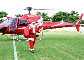Pai Natal desce de helicóptero e entrega  prendas às crianças necessitadas